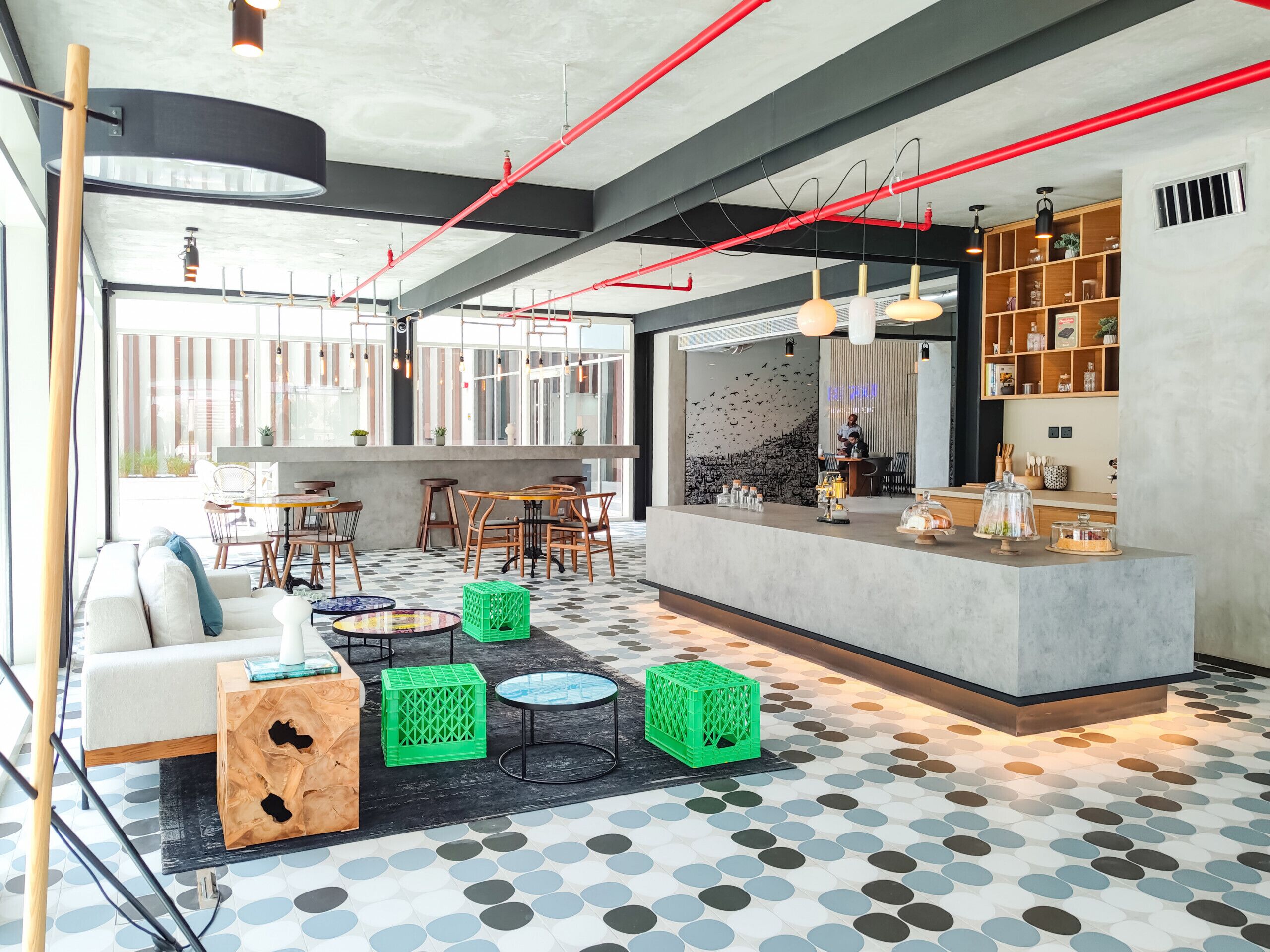 Ein modernes Interieur mit einer zentralen Bar, Sitzgelegenheiten und einem gemusterten Boden.