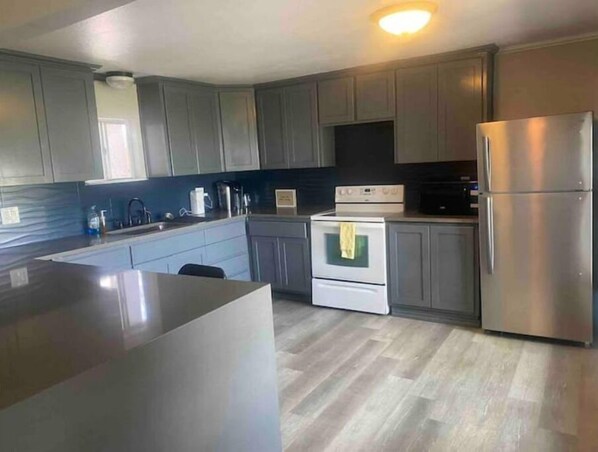 Enjoy cooking in this well-equipped kitchen with a central island, oven, and stainless steel refrigerator.