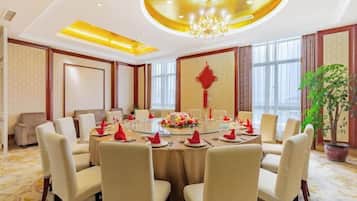 A conference room with a round table, chairs, and a chandelier.