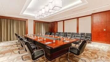 A conference room with a long table, multiple chairs, and a modern chandelier.