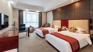 A hotel room with two beds, a desk, a chair, a TV, and a large window. - Hongxing International Hotel (Jing County)