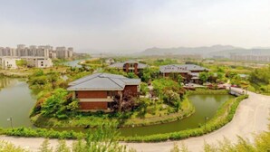 A residential area with houses surrounded by water bodies and greenery. - Hongxing International Hotel (Jing County)