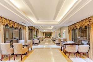 A hotel lobby with a long corridor, seating areas, and large windows. - Hongxing International Hotel (Jing County)
