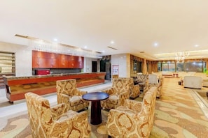 A hotel lobby with a bar area, seating arrangements, and a chandelier. - Hongxing International Hotel (Jing County)