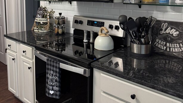 A modern kitchen with white cabinetry, stainless steel appliances, and decorative items on the countertops. - Salisbury Bungalow (Salisbury)