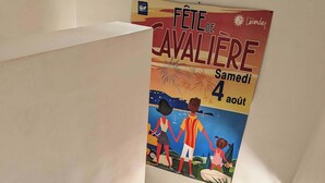 A staircase with beige tiles and a poster advertising 'Fête de Cavalière' on the wall.