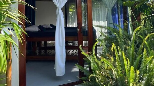 Una habitación con cama, dosel y vistas al exterior.