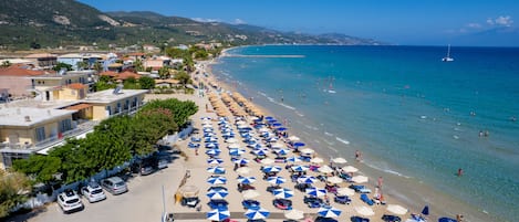 En la playa, playa de arena blanca, camastros y sombrillas