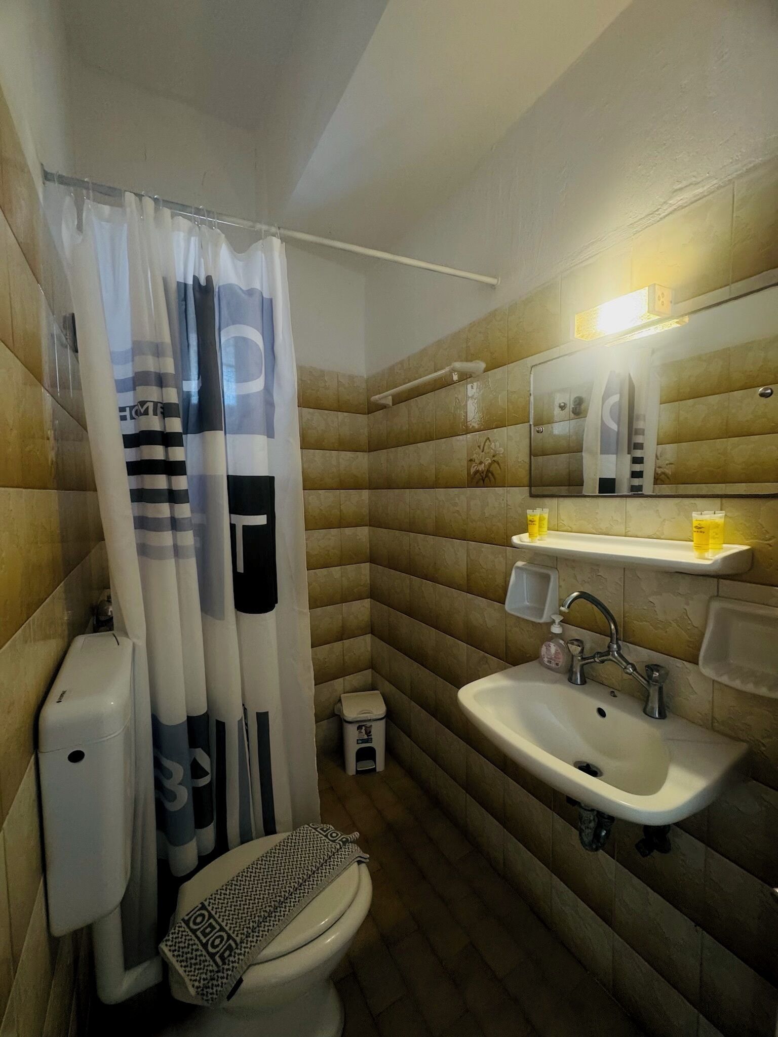 A bathroom with a toilet, sink, and shower area.