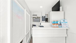 Un'area reception con un bancone bianco, una sedia nera e brochure informative sul bancone.