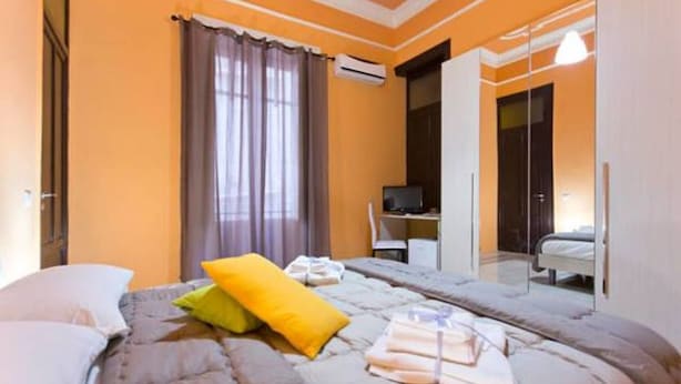 Un dormitorio con cama, escritorio y armario.