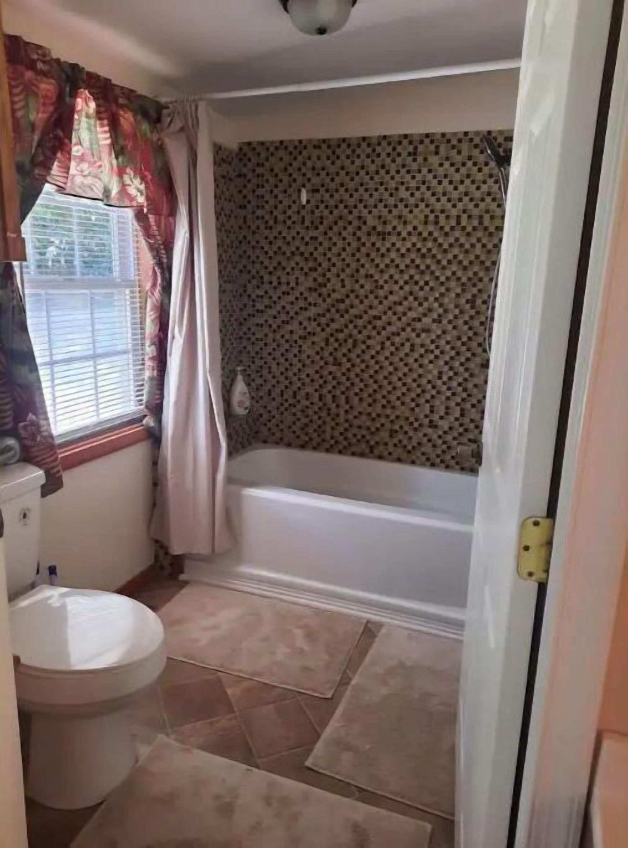 A bathroom with a toilet, a bathtub, and a shower.