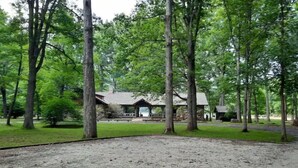 Un terrain de camping doté d’un espace pique-nique abrité, entouré d’arbres.