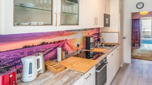 Una cucina moderna con piano cottura integrato, macchina da caffè e tostapane.