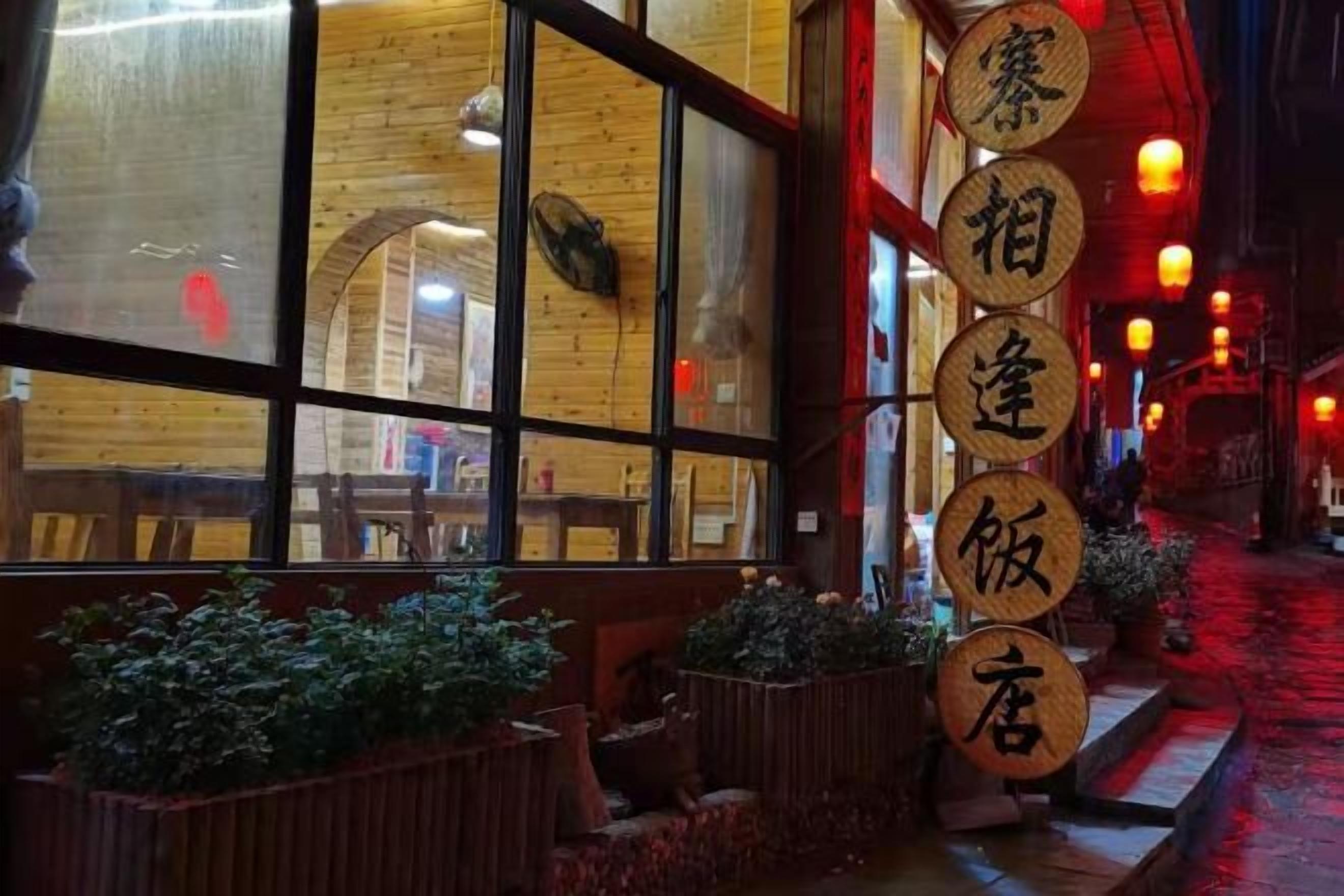 A restaurant with large windows, wooden interior, and a sign with Chinese characters.