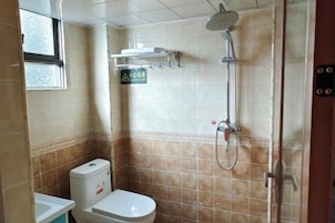 Un baño pequeño con inodoro, ducha y ventana.