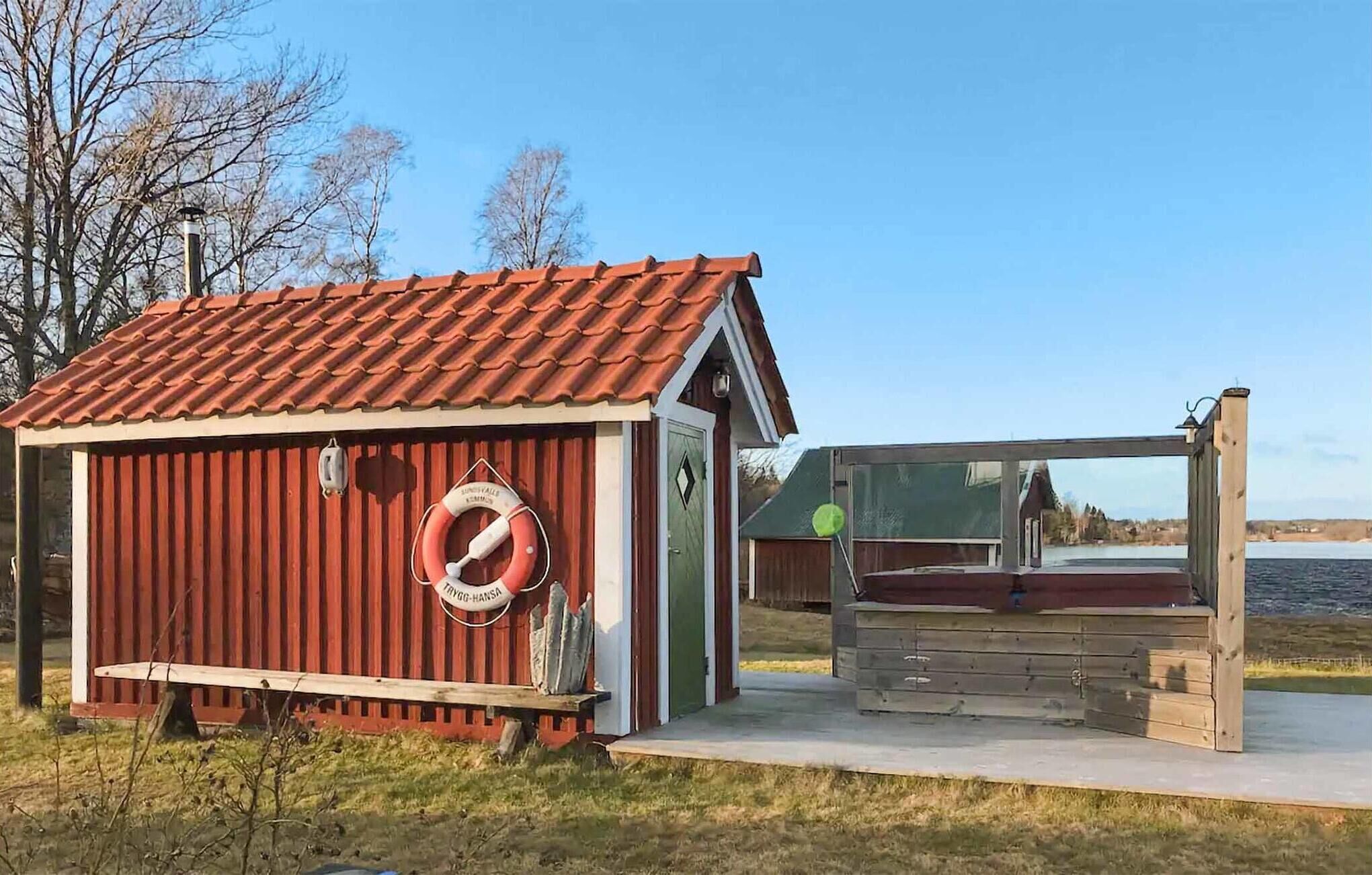 Eine kleine Holzhütte mit rotem Dach und einem Rettungsring an der Wand.