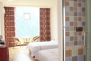 Une chambre d’hôtel avec deux lits, un bureau et une chaise.