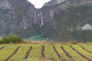 Un paysage montagneux avec une cascade et un lac.