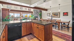 Una cocina amplia con armarios de madera, encimera de granito y lavavajillas integrado.
