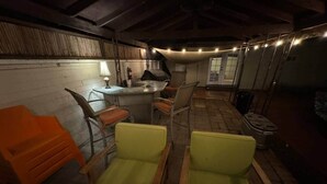 A rustic room with wooden chairs, a small table, and string lights. - 4BR, 2-house compound close to UA, Downtown Tucson (Tucson)