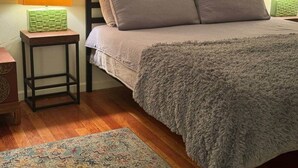 A bedroom with a bed, a nightstand, a lamp, and a rug. - 4BR, 2-house compound close to UA, Downtown Tucson (Tucson)