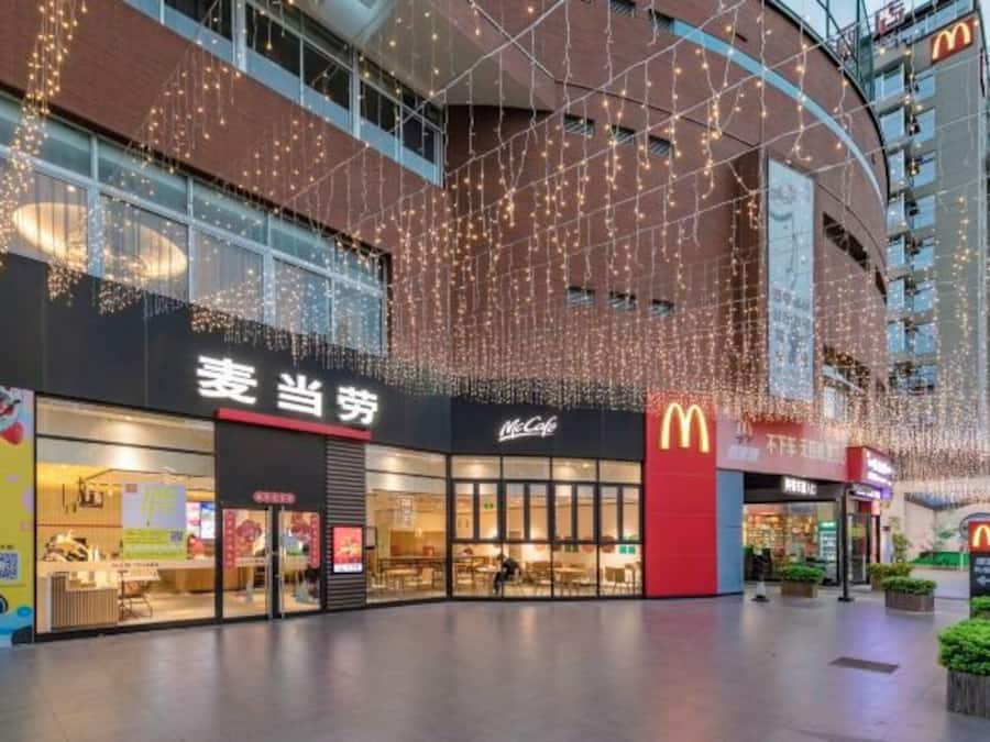 A commercial building with multiple storefronts, including a McDonald's and a store with Chinese signage.
