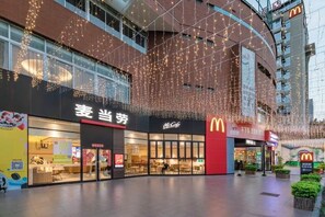 A commercial building with multiple storefronts, including a McDonald's and a store with Chinese signage. - Yishan Meiyuan Hotel (Fuzhou)