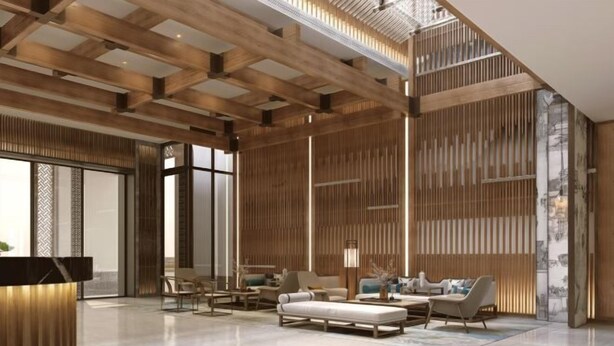 Un hall d’entrée spacieux avec un plafond haut, des lambris en bois et un coin salon moderne comprenant des canapés et des fauteuils.