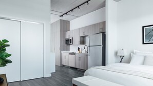 A modern bedroom with a large bed, a bedside table, and a green rug. - Mint House St. Petersburg Downtown by Kasa (St. Petersburg)
