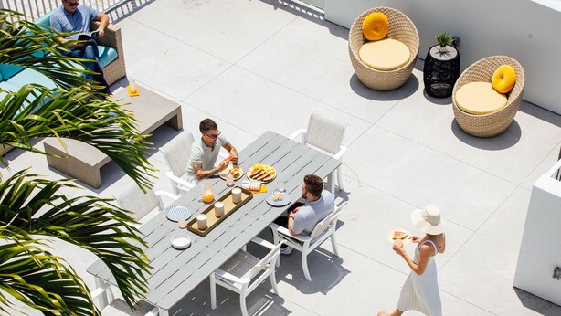 An outdoor patio with a dining table, chairs, and a sofa. - Mint House St. Petersburg Downtown by Kasa (St. Petersburg)