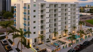 A multi-story hotel with balconies, a swimming pool, and a parking area. - Mint House St. Petersburg Downtown by Kasa (St. Petersburg)