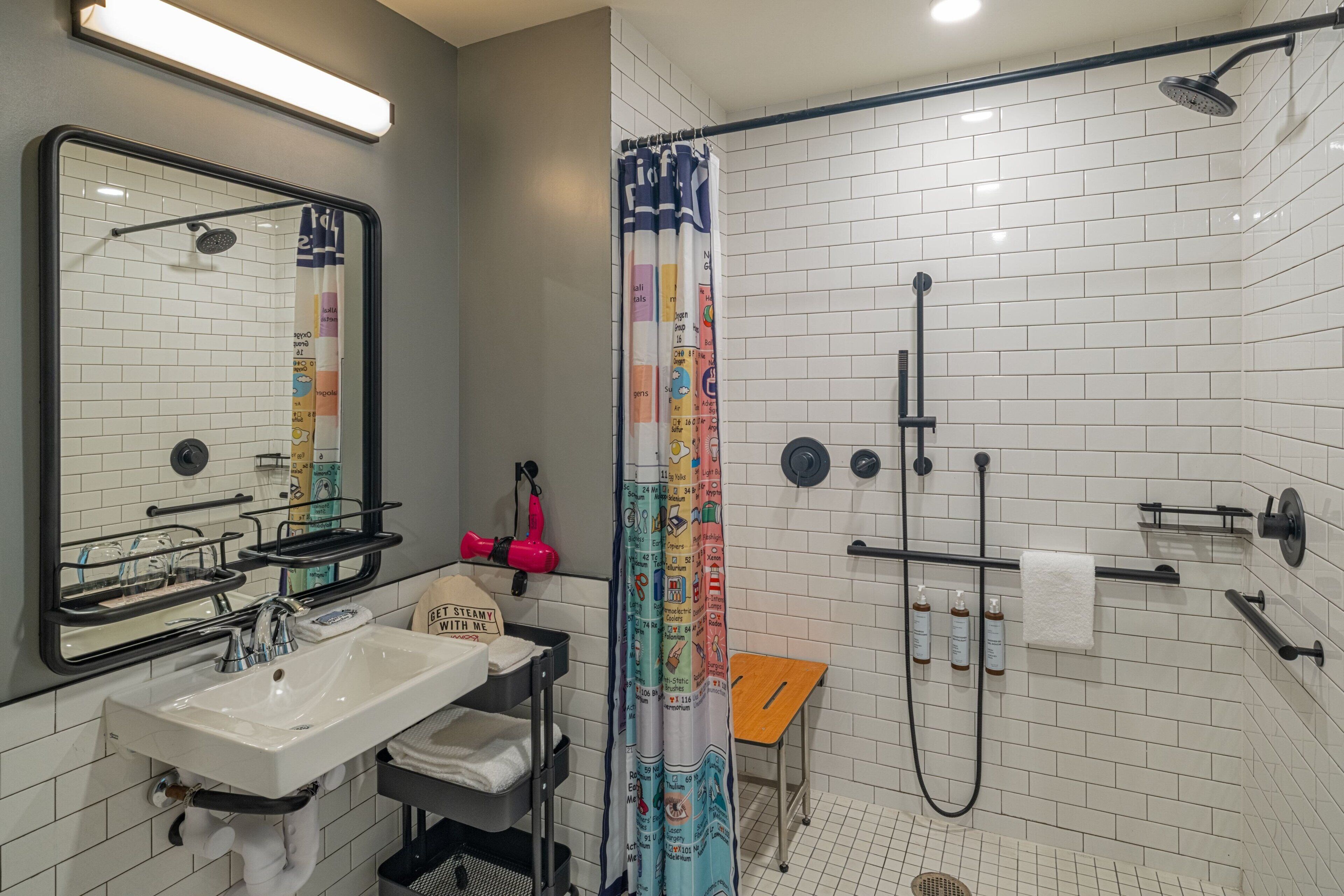 A modern bathroom with a shower, sink, and mirror.