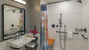 A modern bathroom with a shower, sink, and mirror.