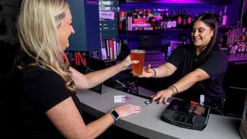 Un bar avec un barman et un client.