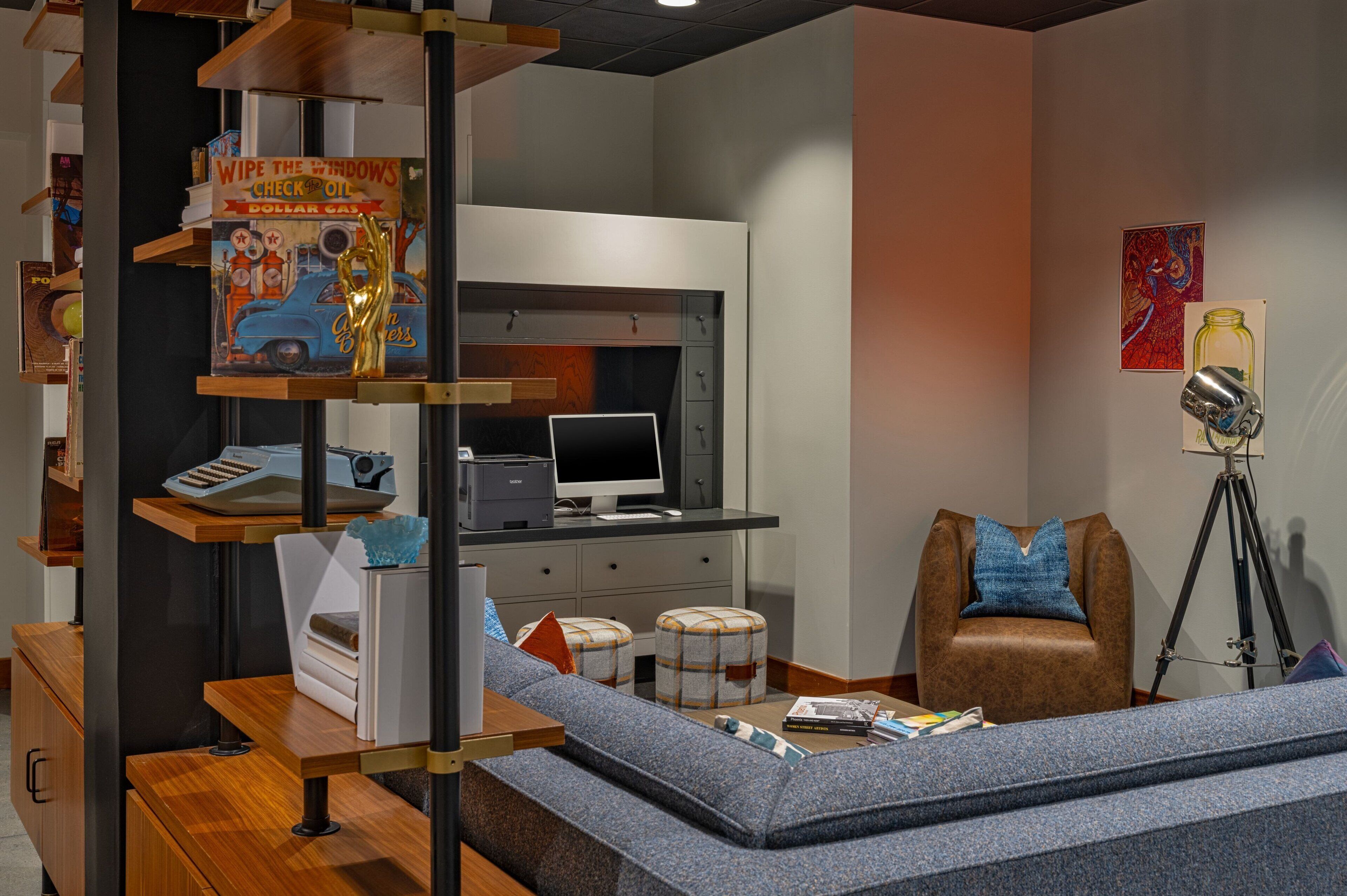 A modern room with a desk, computer, and a cozy seating area.