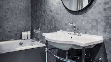 A modern bathroom with a bathtub, a sink, and a mirror.