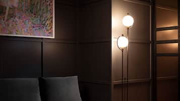 A dark room with a sofa and two floor lamps.