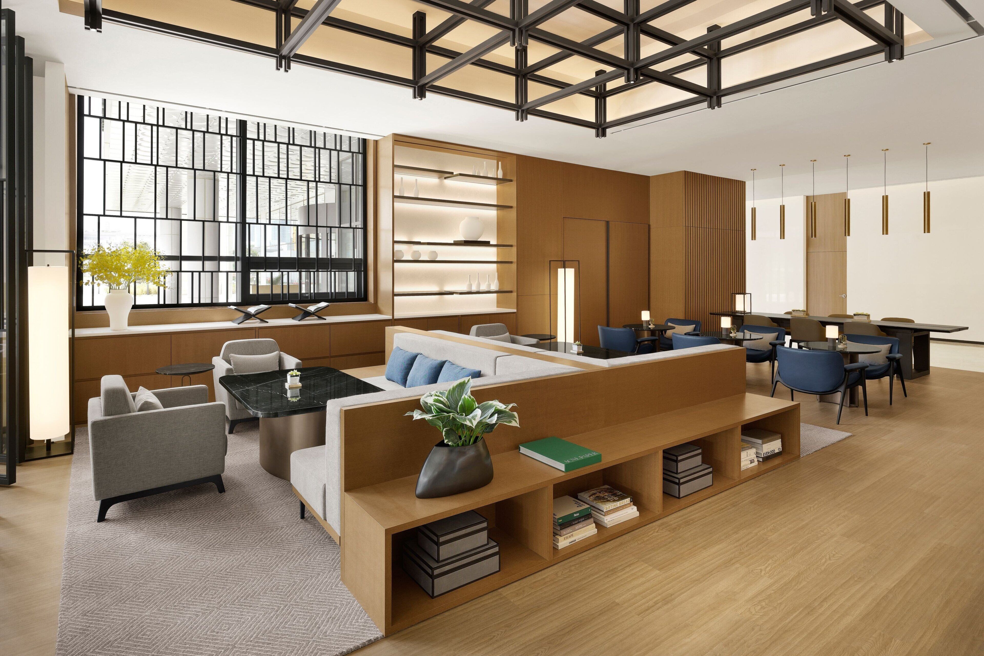 A modern living room with a sectional sofa, a coffee table, and a bookshelf.