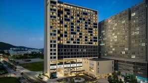Un hôtel moderne à plusieurs étages, doté d’une cour intérieure et d’un parking.