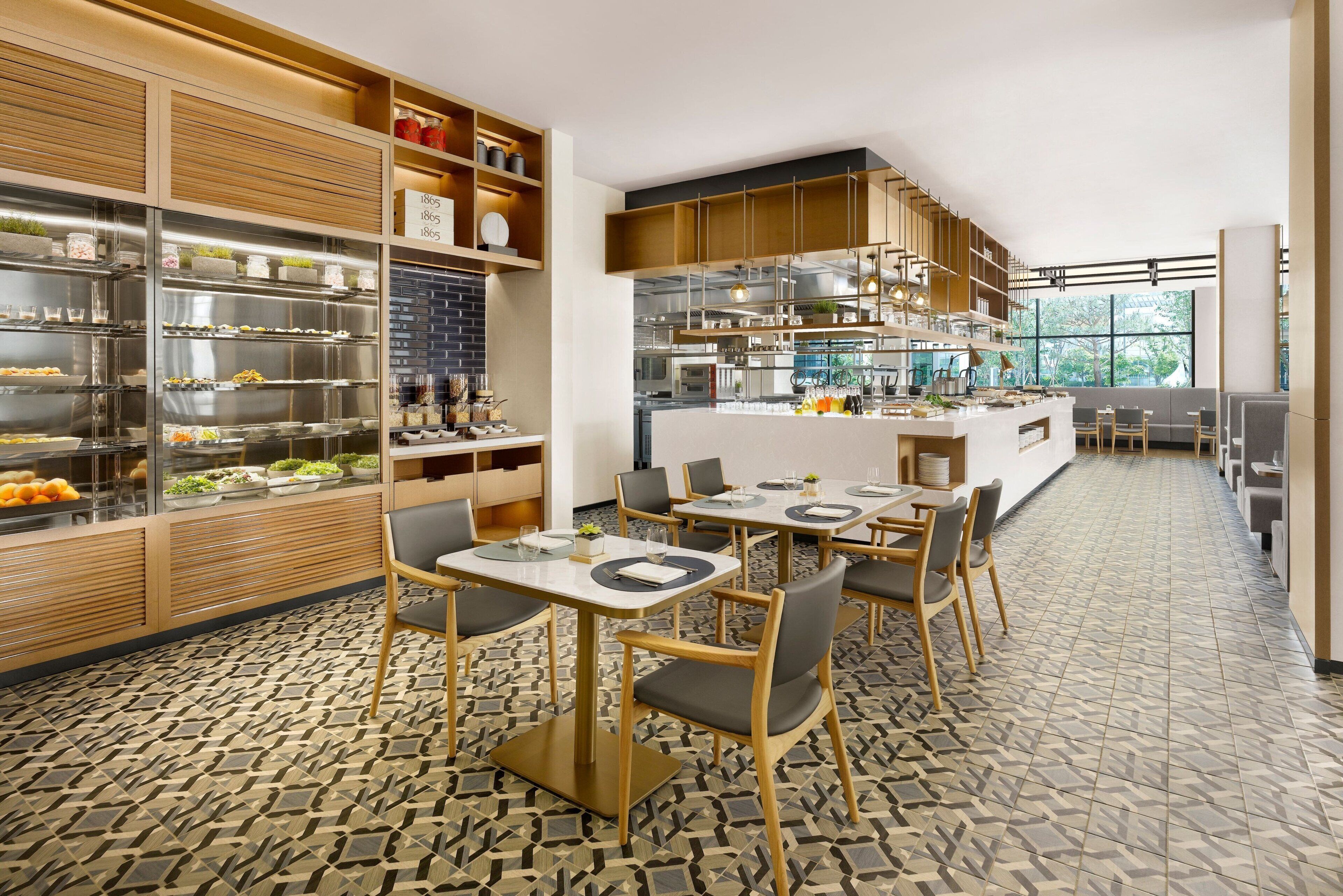 A modern restaurant with a central island, multiple seating areas, and a patterned floor.