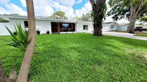 A modern house with a well-maintained lawn, a garage, and a driveway.