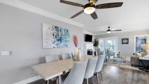 A dining area with a wooden table and grey chairs, a ceiling fan, and a large abstract painting on the wall. - Tranquil waterfront getaway (Ashland City)
