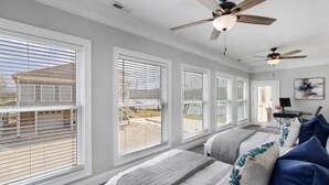 A bedroom with a large window, a ceiling fan, and a bed with pillows. - Tranquil waterfront getaway (Ashland City)