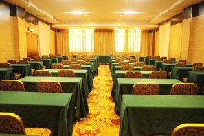 A conference room with rows of tables and chairs, a carpeted floor, and windows with curtains. - Sheng Shi Jin Hai Grand Hotel (Nayong)