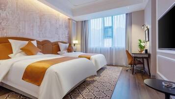 A hotel room with a large bed, a desk, and a TV.