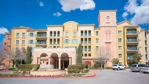 A multi-story hotel with a central courtyard, balconies, and a prominent tower. - Pool-side 2 Bedroom Viera condo! (Henderson)