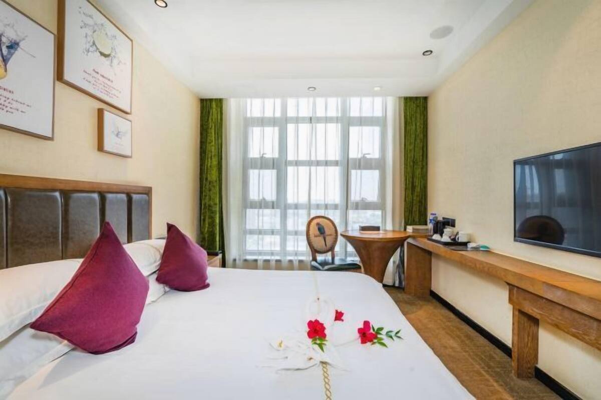 Une chambre d’hôtel avec un lit, une télévision, un bureau et une chaise.