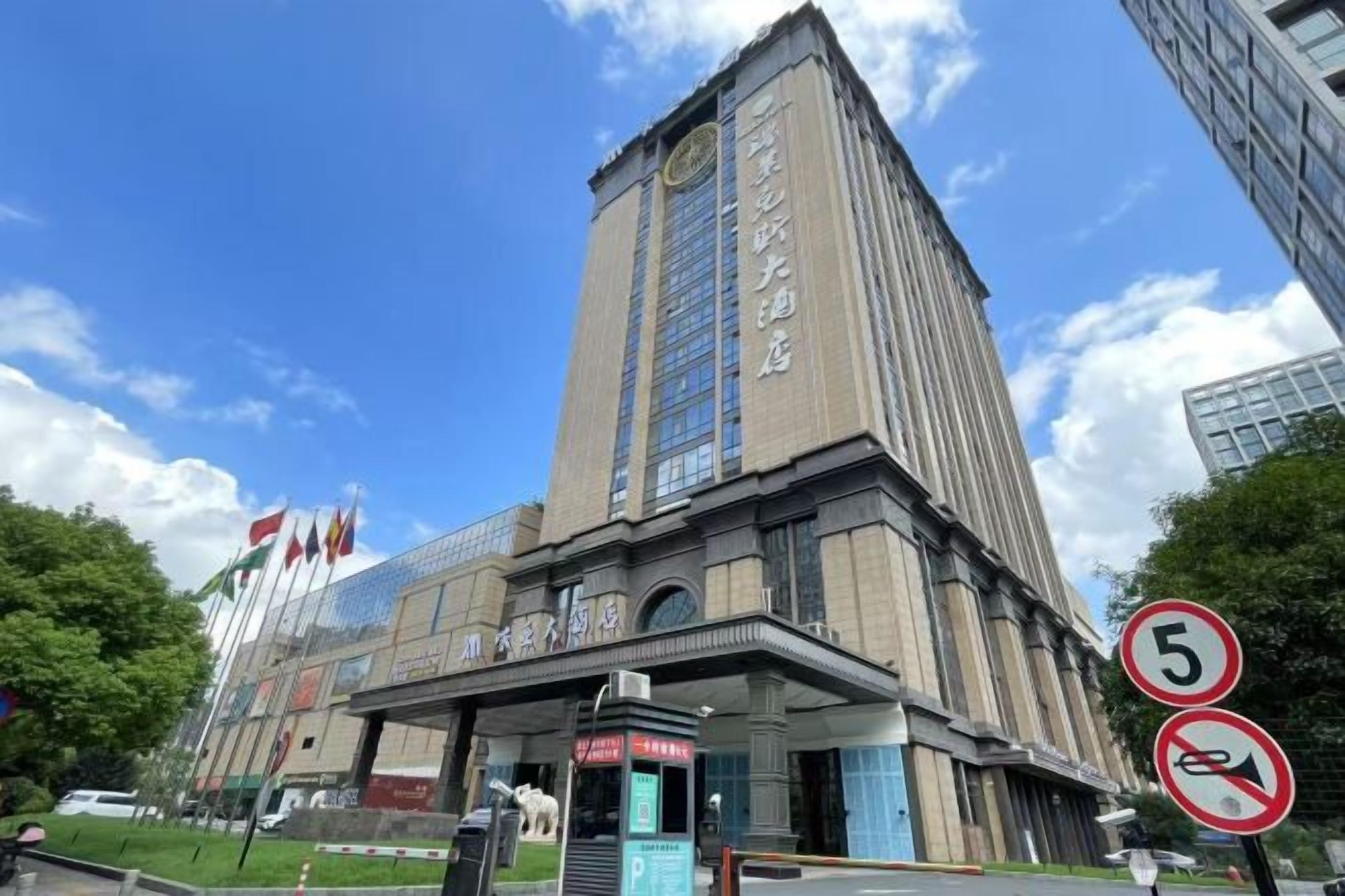 A tall building with a prominent entrance and a clock tower.