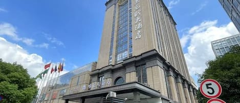A tall building with a prominent entrance and a clock tower.